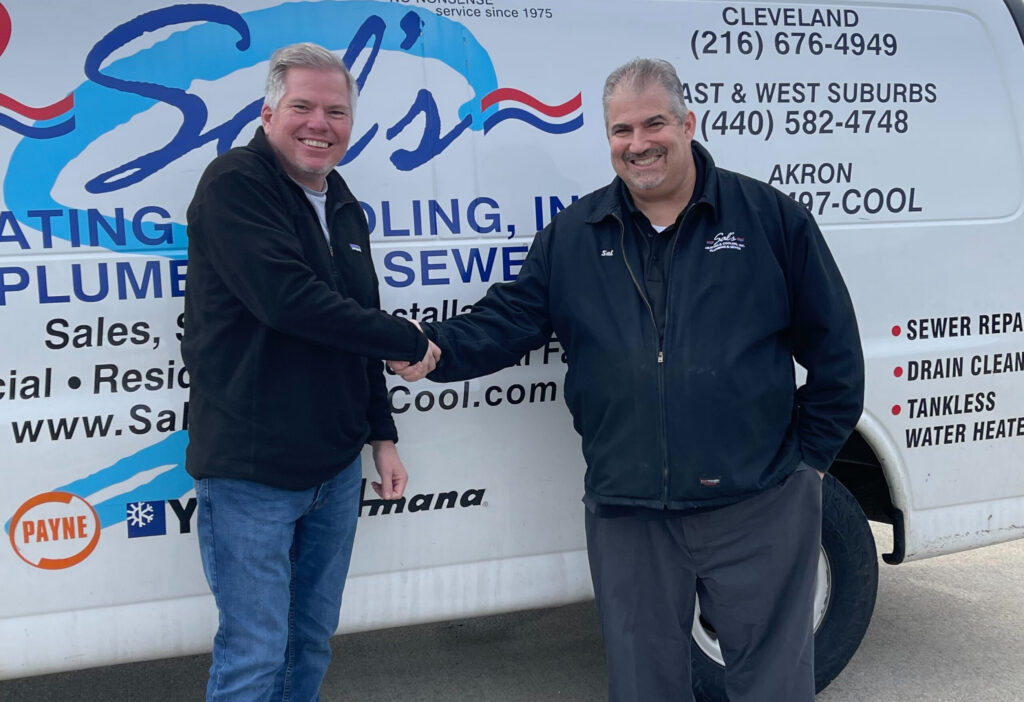 Two men are shaking hands and smiling in front of a service van labeled "Sal’s Heating & Cooling, Inc."—a great visual for our about us page, showcasing our team’s friendly approach and professional services.
